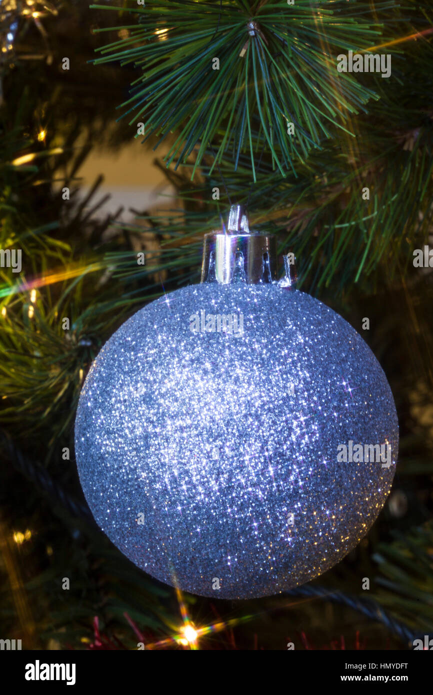 Decorazione per albero di Natale appeso a un albero con luci colorate Foto Stock