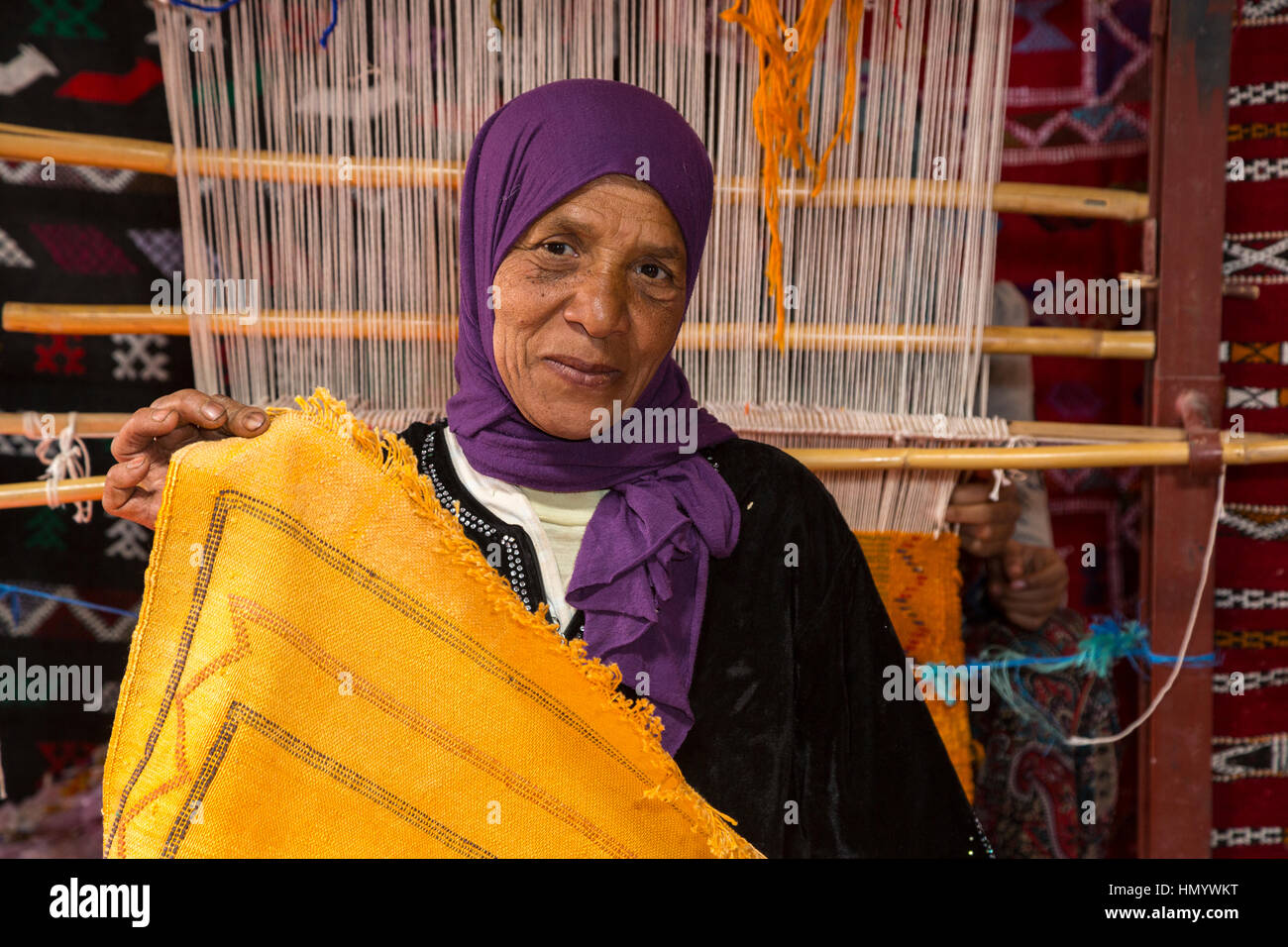 Il Marocco. Amazigh donna berbera visualizzazione Rug, Ait Benhaddou Ksar, un sito del Patrimonio Mondiale. Foto Stock