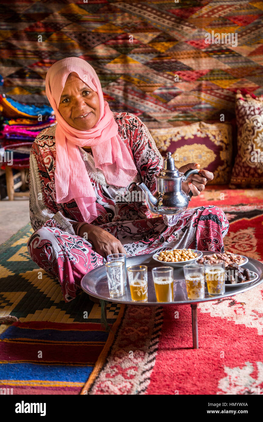 Il Marocco. Donna di etnia Arab-Berber versando il tè per gli ospiti. Ait Benhaddou Ksar, un sito del Patrimonio Mondiale. Foto Stock