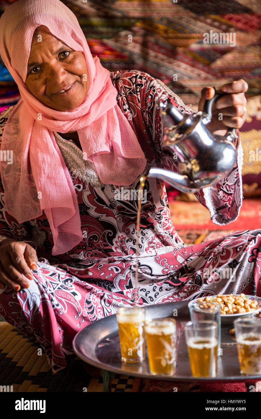 Il Marocco. Donna di etnia Arab-Berber versando il tè per gli ospiti. Ait Benhaddou Ksar, un sito del Patrimonio Mondiale. Foto Stock