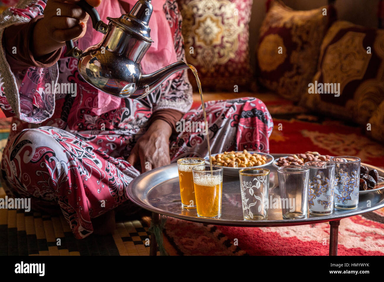 Il Marocco. Donna di etnia Arab-Berber versando il tè per gli ospiti. Ait Benhaddou Ksar, un sito del Patrimonio Mondiale. Foto Stock