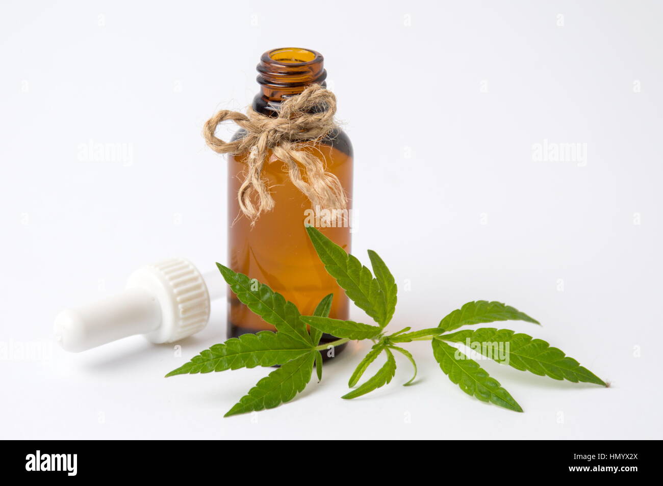 Foglie di cannabis e olio su sfondo bianco Foto Stock