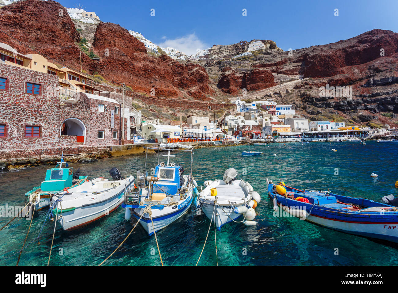 Barche di pescatori locali ormeggiata ai piedi delle falesie a Baia di Ammoudi, Oia - Santorini, una greca mediterranea isola delle Cicladi gruppo Foto Stock