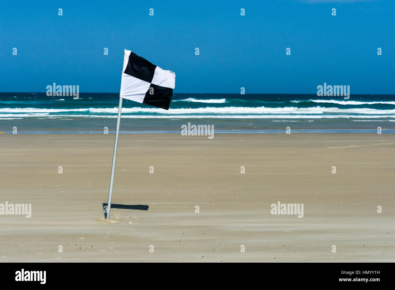 Una spiaggia salvavita di bandiera identifica il surf mezzo di salvataggio zona di confine. Foto Stock