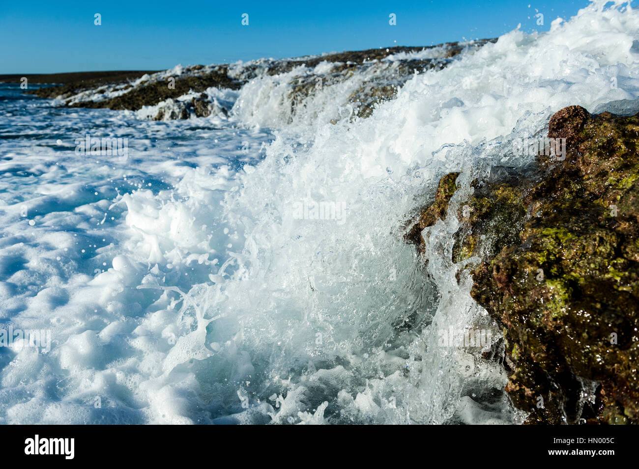 Cascate di acqua dalla superficie esposta una barriera corallina con la bassa marea. Foto Stock