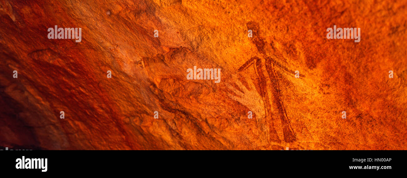Antica aborigena Gwion Gwion pitture rupestri anche sapere come Bradshaw arte rock dotato di mascherine per stencil a mano e una figura umana Foto Stock