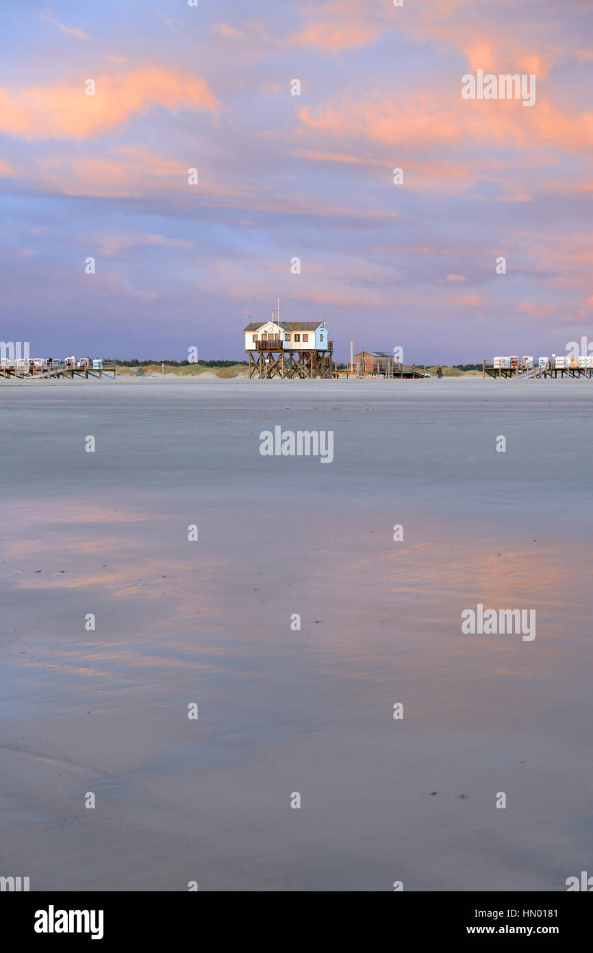 Atmosfera serale, il tramonto sulla spiaggia di sabbia con stazioni palafitticole, Sankt Peter-Ording, Schleswig-Holstein il Wadden Sea National Park Foto Stock