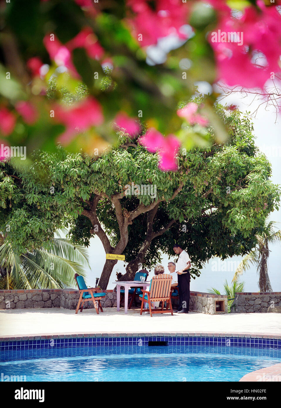 Un cameriere prende un ordine dalla piscina principale a Stonefield Estate Villa Resort di Santa Lucia. Soufriere, St. Lucia. Foto Stock