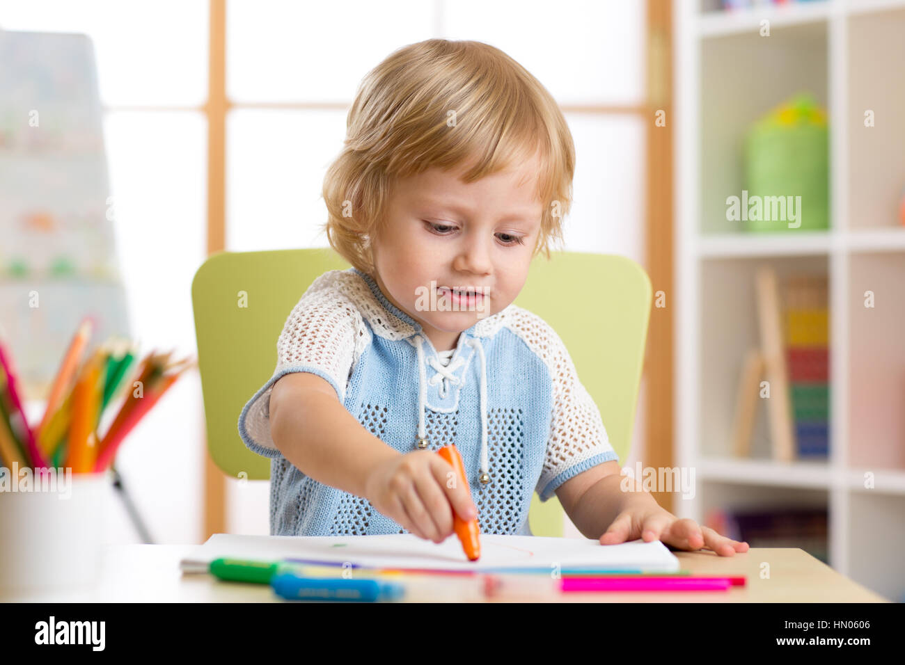 Kid little boy dipinge nel suo vivaio a casa Foto Stock