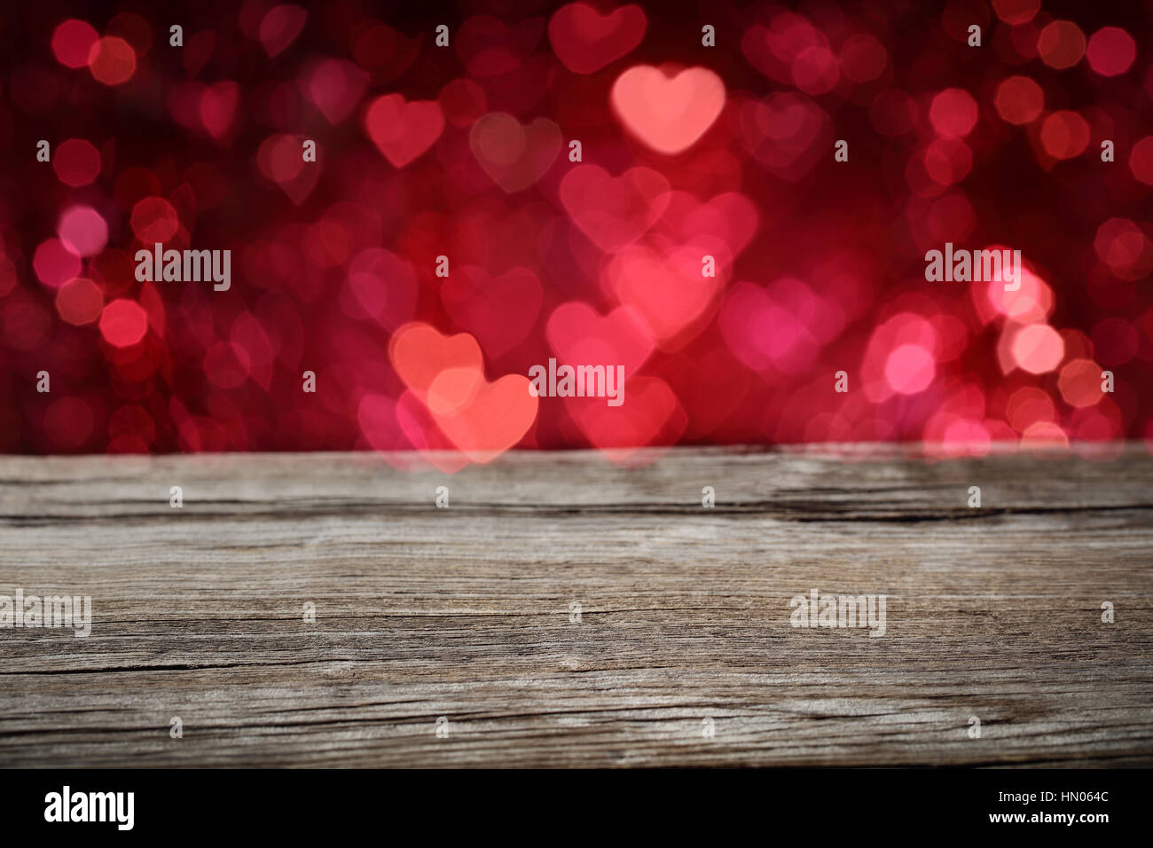 Vuoto di legno tavolo con cuore sfocata bokeh sfondo. Foto Stock