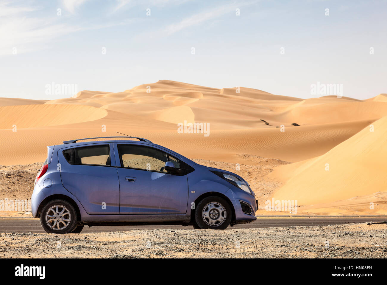 Piccola auto a noleggio nel deserto una strada per la duna Moreeb in Liwa Oasis area. Emirato di Abu Dhabi, Emirati Arabi Uniti Foto Stock