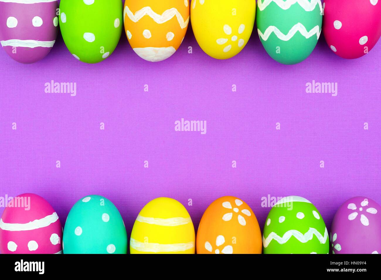 Coloratissimo uovo di pasqua doppio bordo su un morbido viola lo sfondo della carta Foto Stock