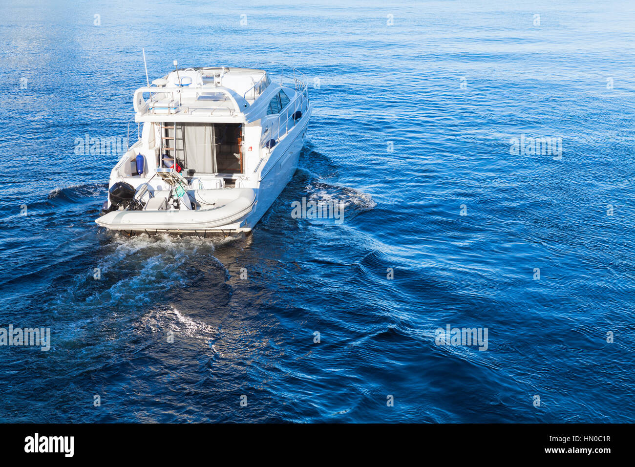 Piccolo piacere bianco va in motoscafo sul mare blu acqua, vista posteriore Foto Stock