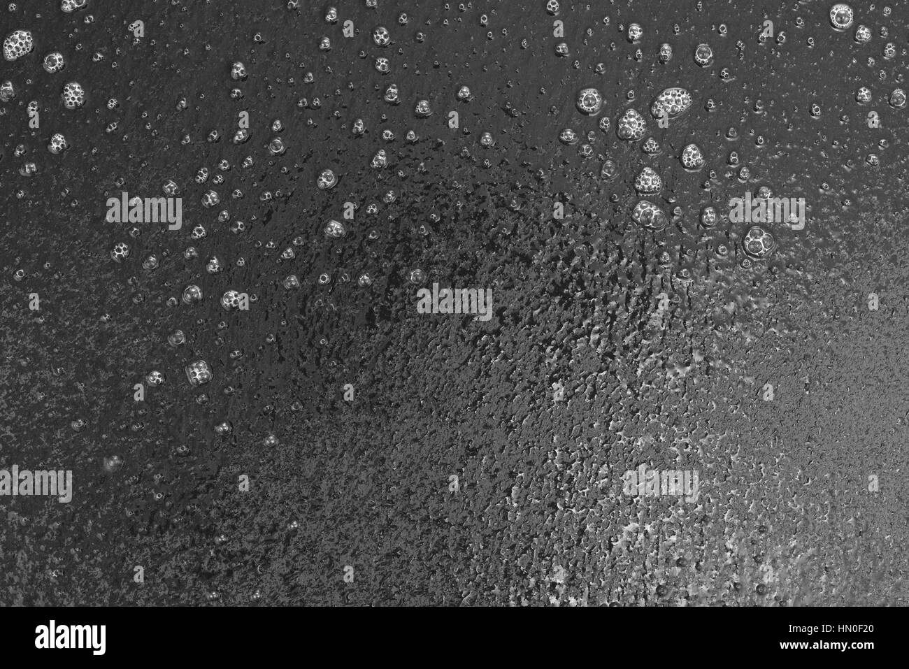 Un nero ardesia tavolo di essere puliti con un detergente liquido. Foto Stock