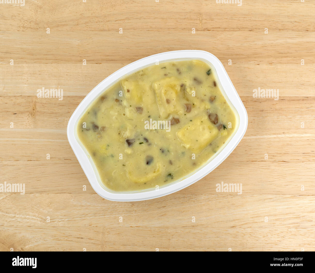 Vista dall'alto di un ravioli al formaggio e salsa di funghi TV cena su una tavola di legno alto. Foto Stock