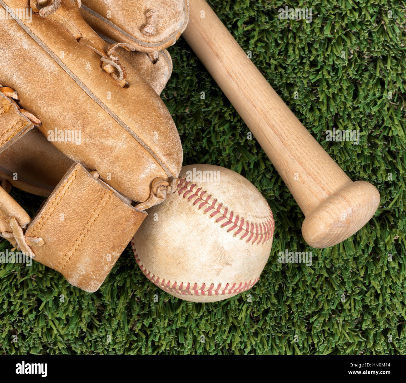 Vista piana della vecchia guanto da baseball, la sfera e la bat sull'erba Foto Stock