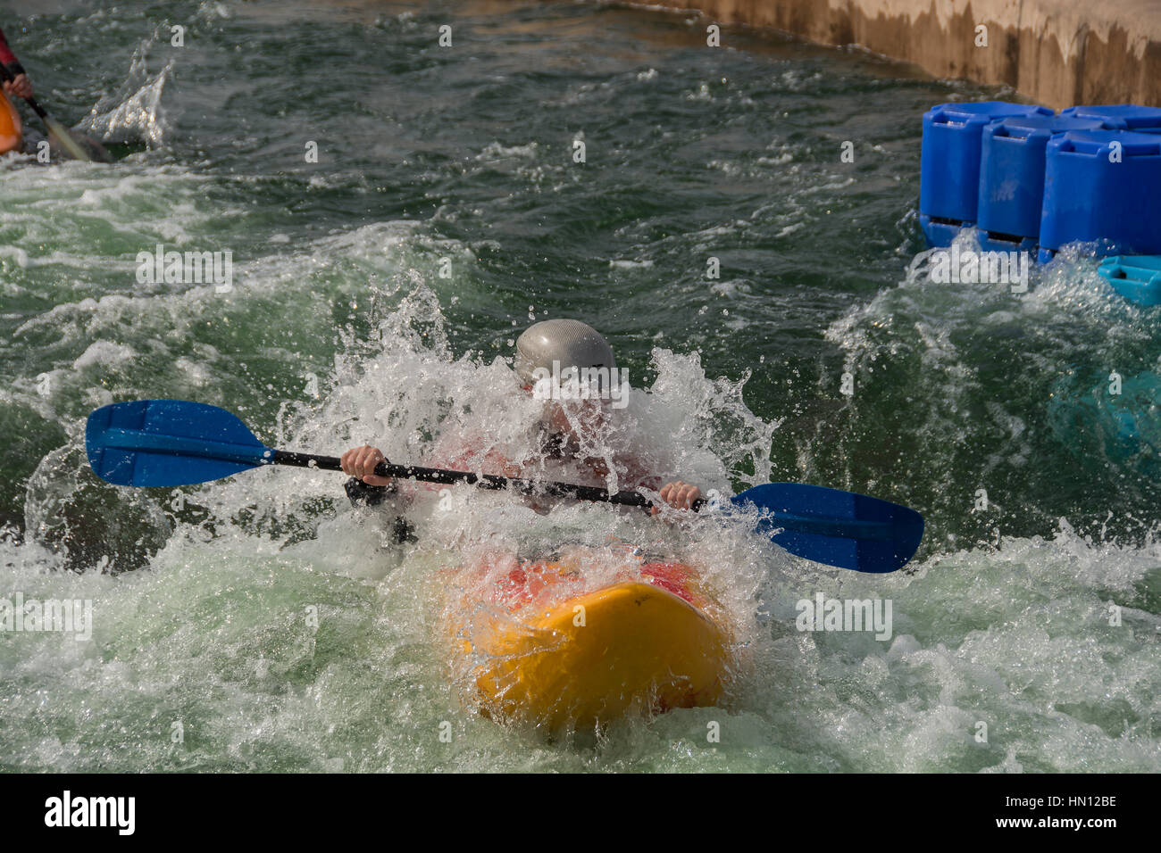 Un kayaker navigazione attraverso alcuni molto ruvida rapids su un uomo bianco fatto il corso di acqua Foto Stock