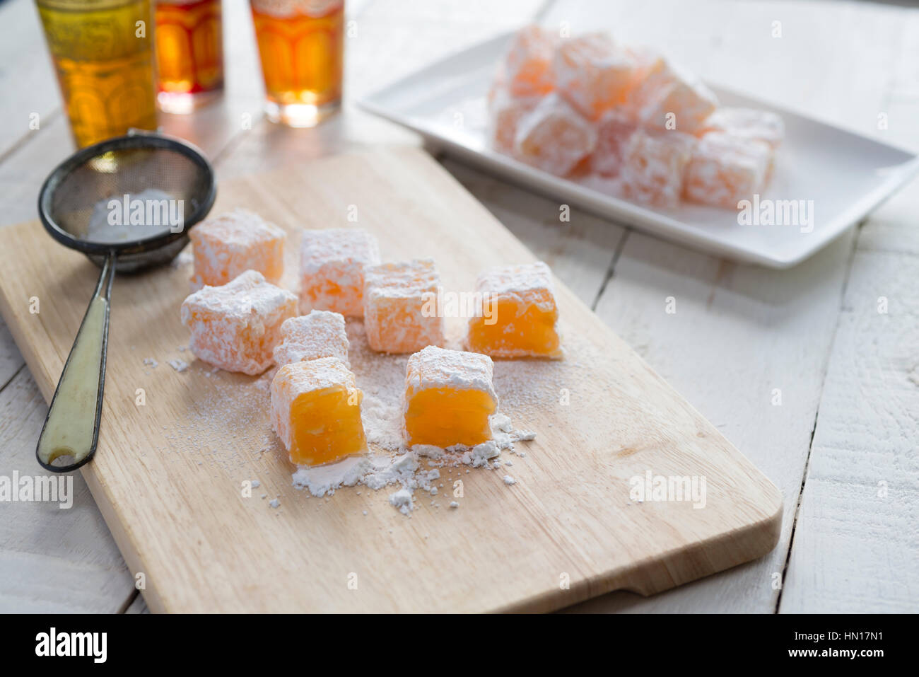 Il taglio in casa arancione e mandorla delizie turche in quadrati e spolverata con zucchero a velo. Foto Stock