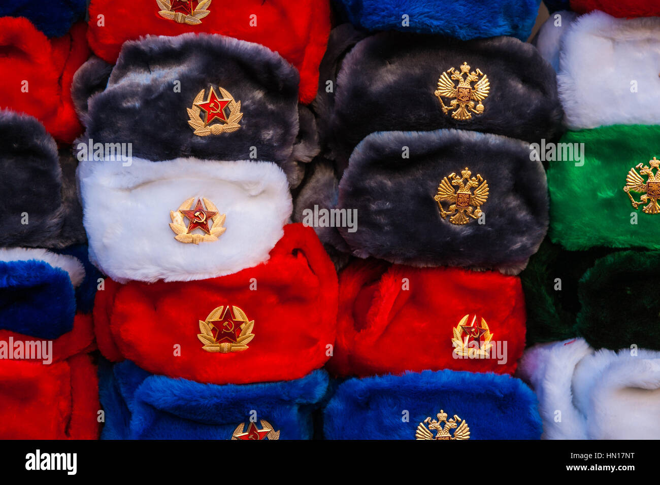 Pila di tradizionale inverno russo pelliccia con tappi auricolari a lembi esposti per la vendita come souvenir. Rosso, bianco, blu, nero, verde caps Foto Stock