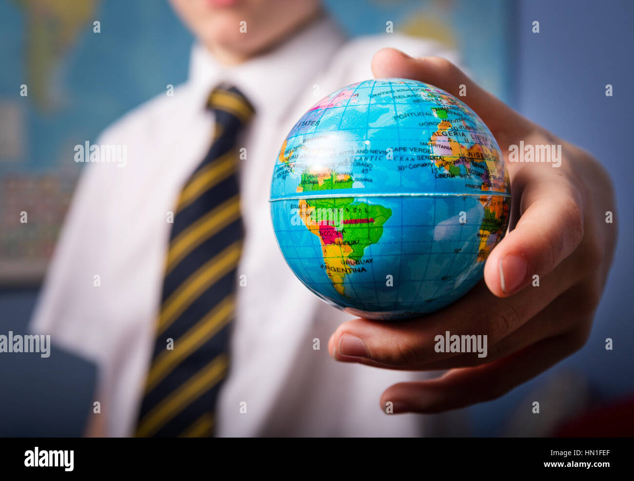 Un ragazzo scuola tenendo un globo Foto Stock