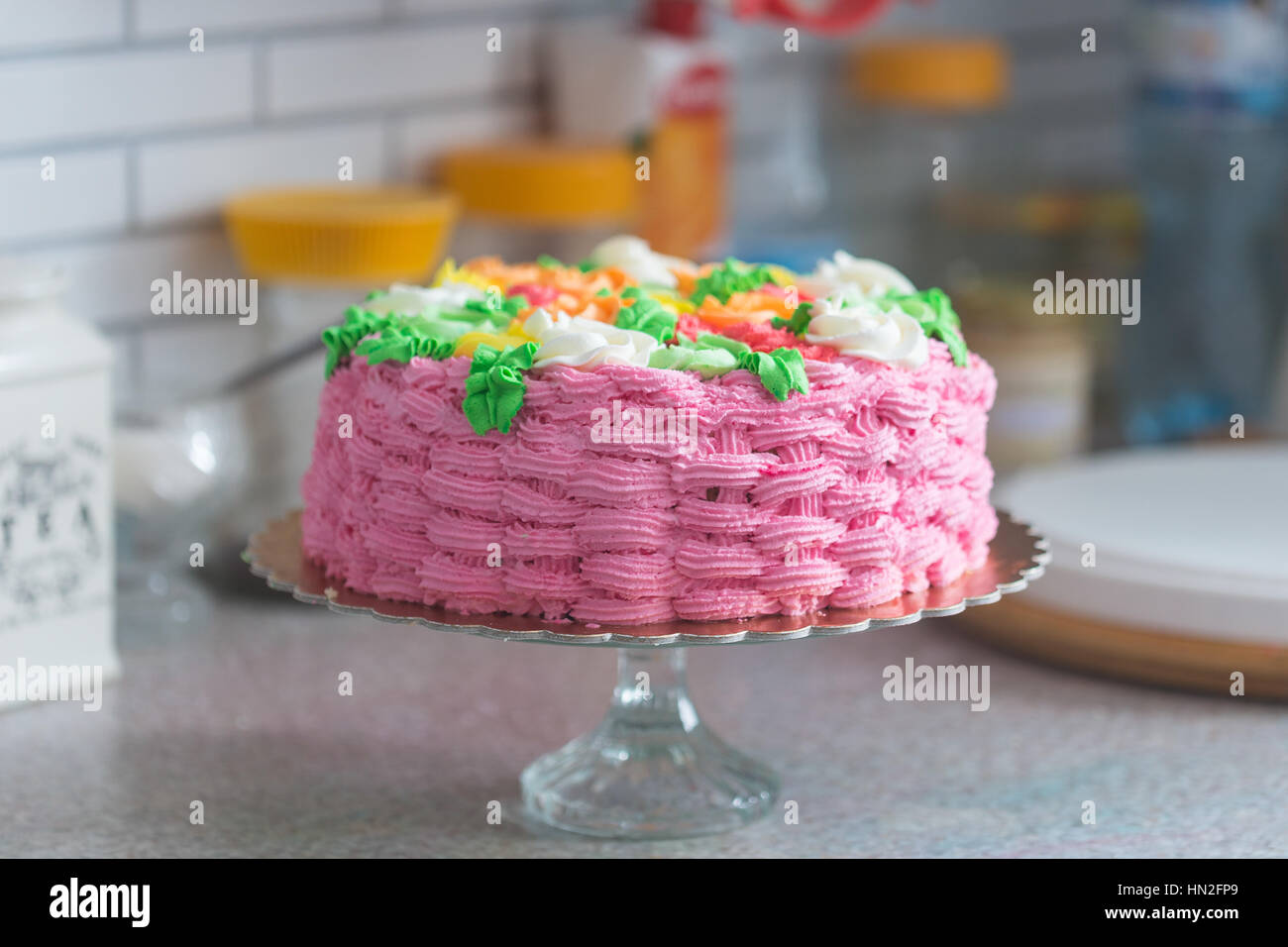 Torta colorata con configurazione a reticolo sulla superficie della torta stand Foto Stock