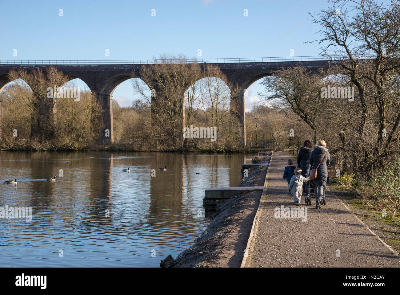 Le madri con bambini piccoli a piedi di colore rossastro Vale Country Park, Greater Manchester, Inghilterra Foto Stock