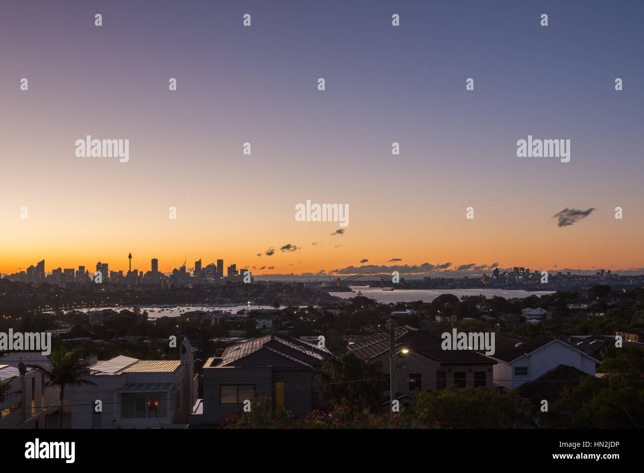Skyline di Sydney visto dal lontano oriente del porto al tramonto. Sydney, Australia Foto Stock