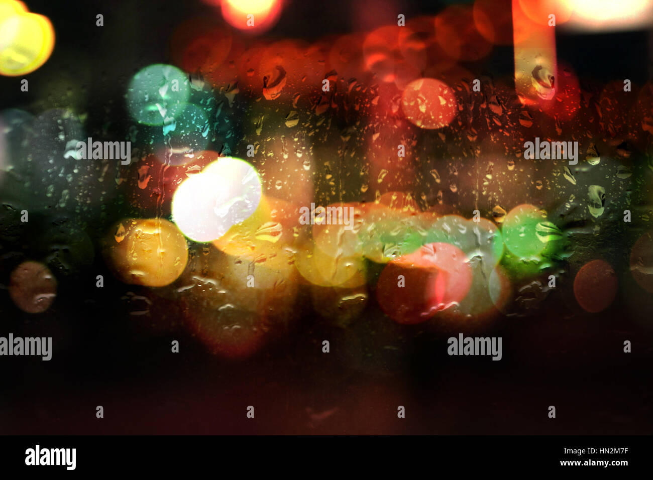 Finestra bagnato con notte luci bokeh di fondo Foto Stock