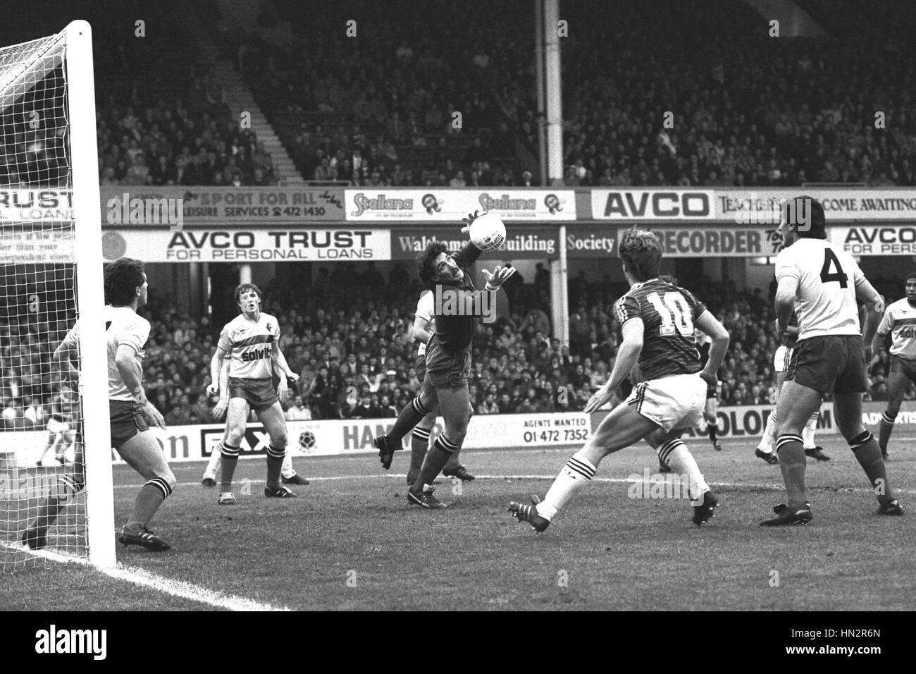 Watford portiere Tony Coton ottiene alle prese con una feroce volley da Tony Gale (non mostrato) del West Ham United. West Ham numero 10 è Tony Cottee. Foto Stock