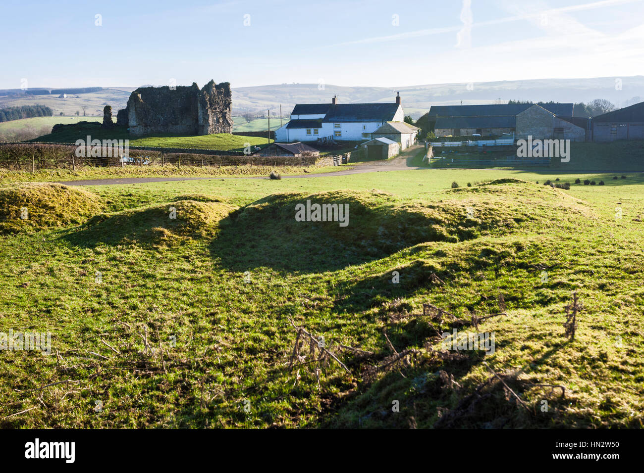 Il castello medievale visto da i resti del forte romano (Fanum Cocidi) a Bewcastle, Cumbria Regno Unito Foto Stock