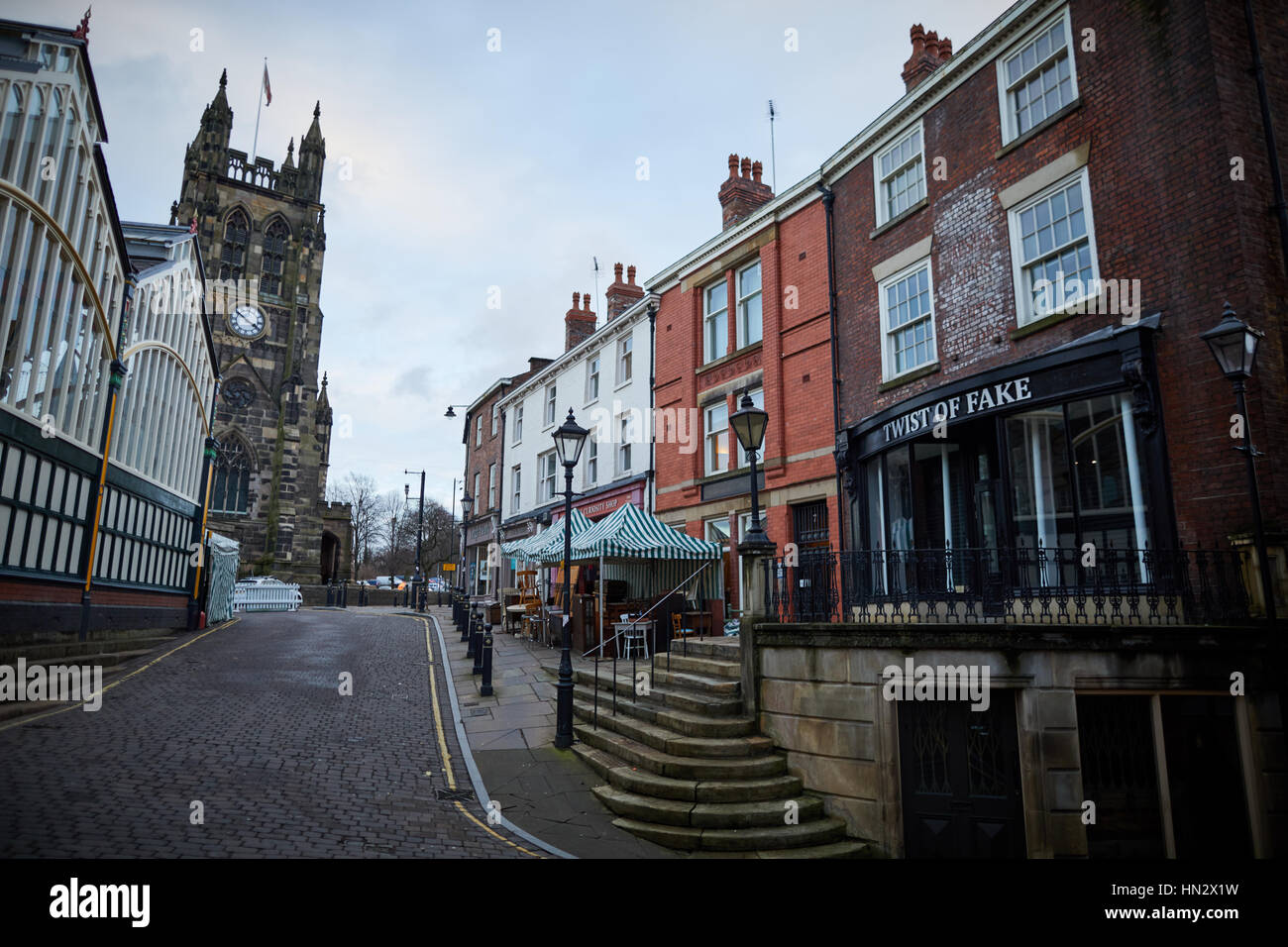 Punto di riferimento la chiesa di Saint Mary a Stockport mercato su una noiosa giornata invernale che mostra la parte esterna del Mercato Coperto Hall e negozi indipendenti nella storica bu Foto Stock