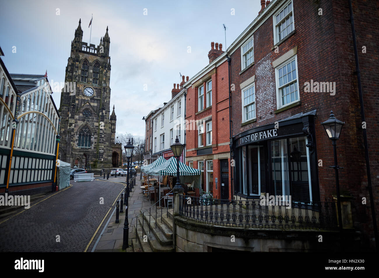 Punto di riferimento la chiesa di Saint Mary a Stockport mercato su una noiosa giornata invernale che mostra la parte esterna del Mercato Coperto Hall e negozi indipendenti nella storica bu Foto Stock