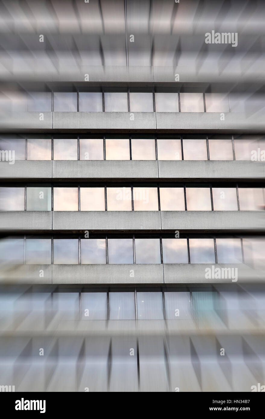 Immagine concettuale di una città di cemento grigio blocco ufficio Costruzione di finestre con sfocatura zoom effetto applicato Foto Stock