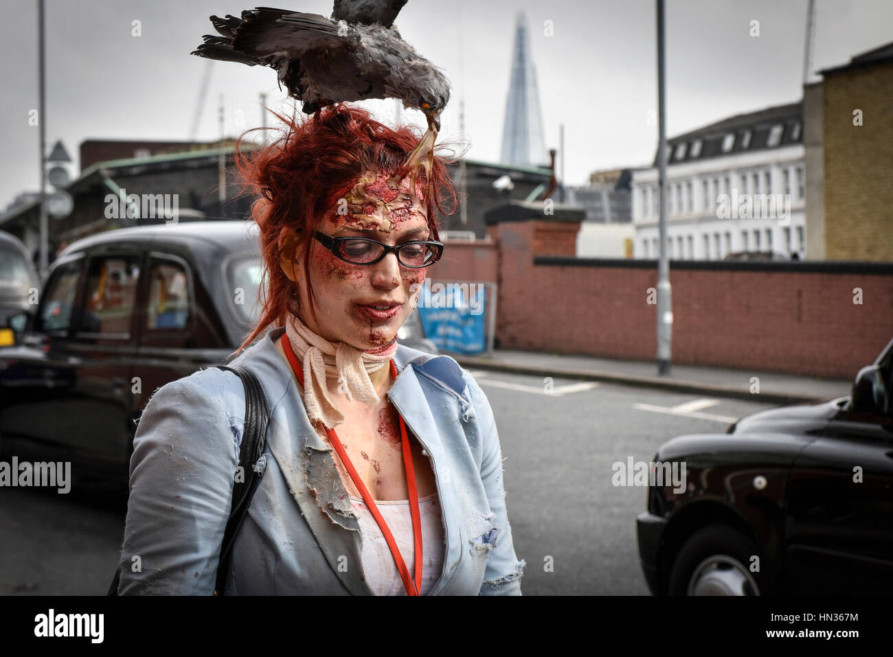 Uno zombie con un uccello ripiene sulla sua testa si unisce il suo undead amici in preparazione per la loro annuale mondo zombie giorno shuffle e shamble. Foto Stock