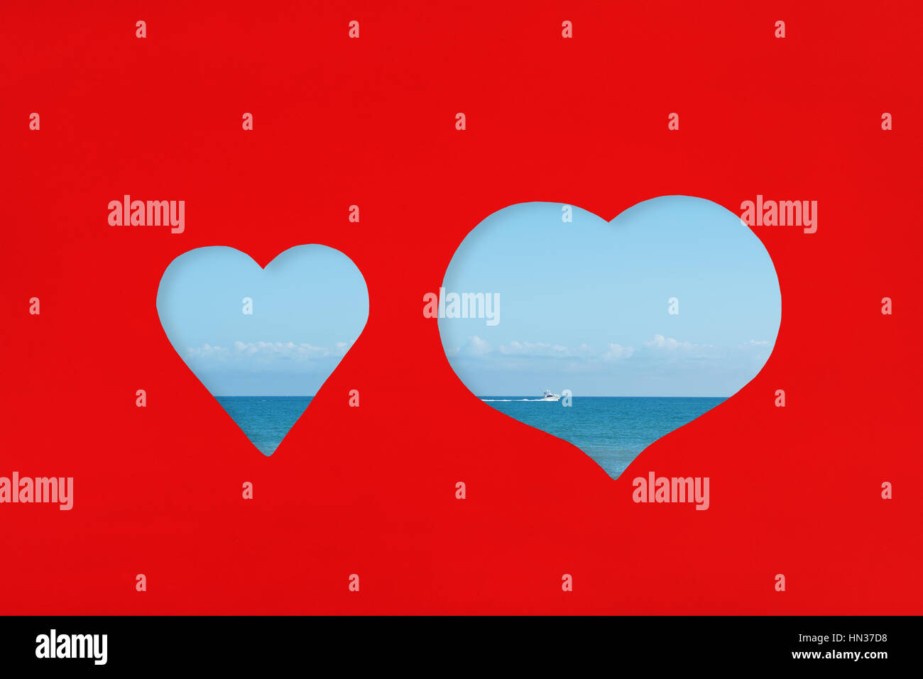 Cuori taglio sagomato su carta rossa con vista sul mare attraverso.Amore e concetto di vacanza. Foto Stock