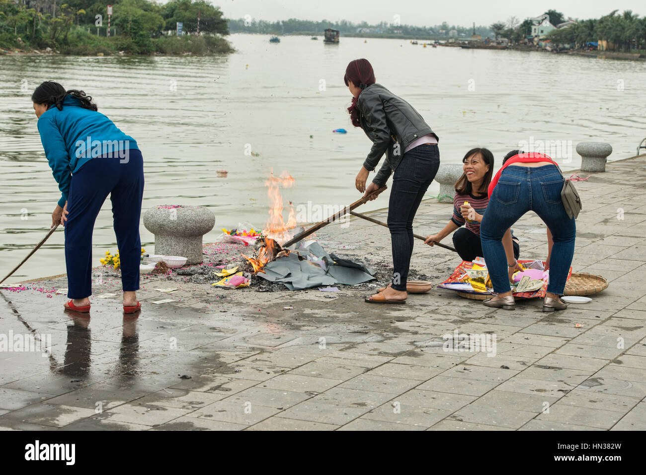 La masterizzazione di vecchi calendari e carta moneta in preparazione per il Tet vietnamita Anno nuovo, Hoi An, Vietnam Foto Stock