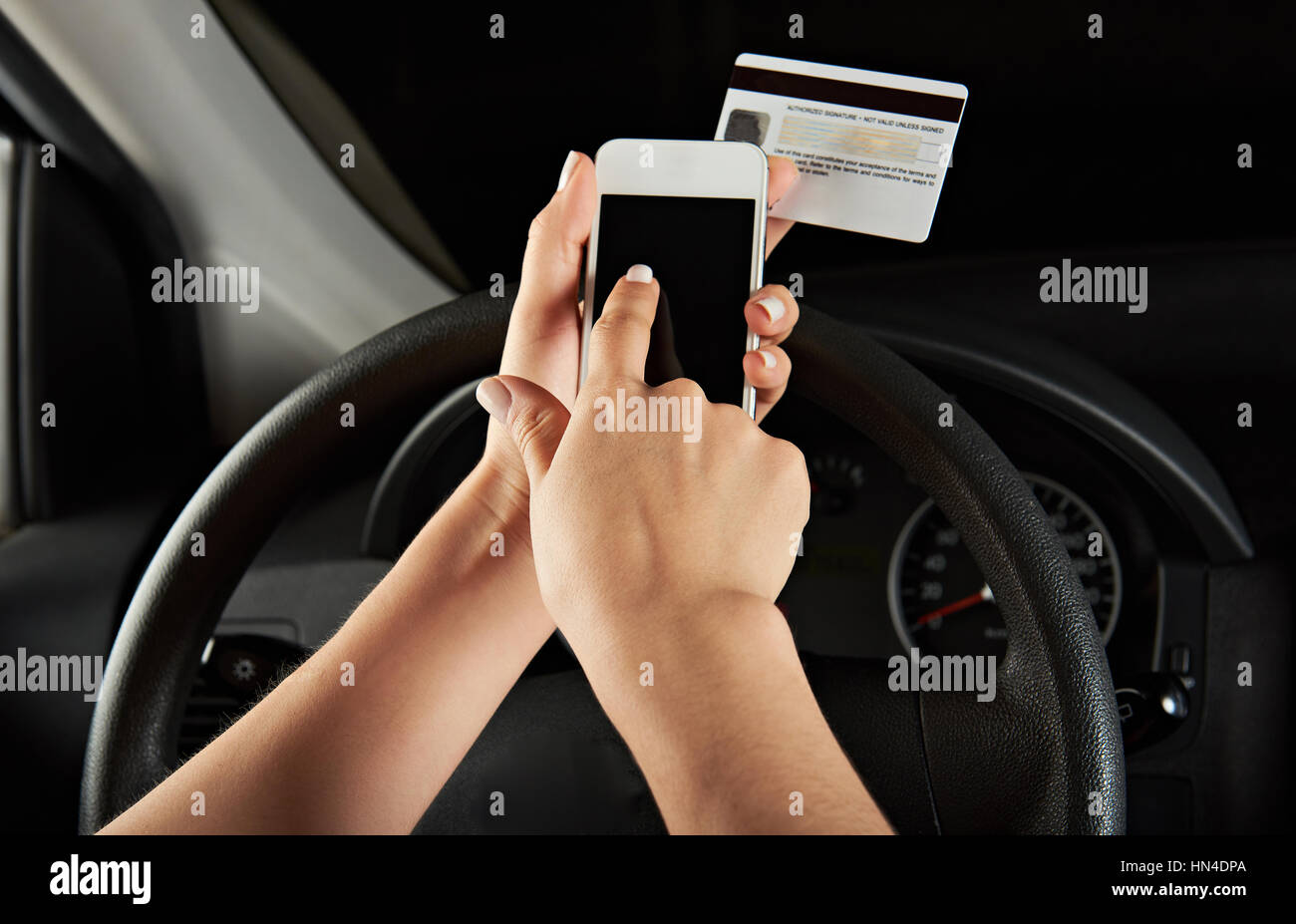Driver tramite carta di credito per pagare con il telefono Foto Stock