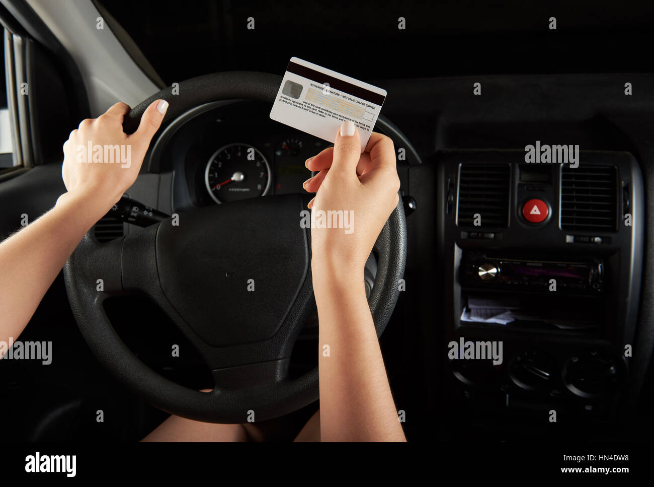 Tenere driver carta di credito nella parte anteriore del cruscotto di automobile Foto Stock