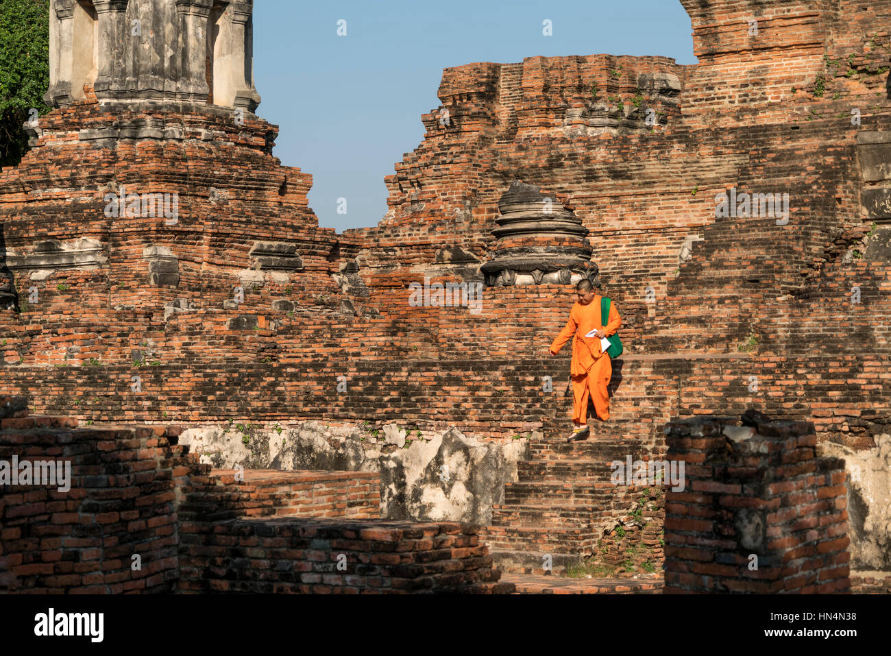 Mönch auf den Stufen der buddhistischen Tempelanlage Wat Phra Ram Geschichtspark im Ayutthaya, Thailandia, Asien | Monaco salendo la scalinata del budd Foto Stock
