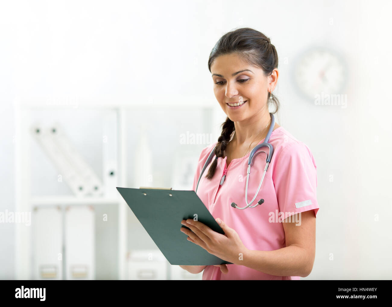 Bella donna sorridente medico paziente attesa elenco Cronologia clipboard a pastiglia nella stanza di ospedale. Uno stile di vita sano concetto Foto Stock