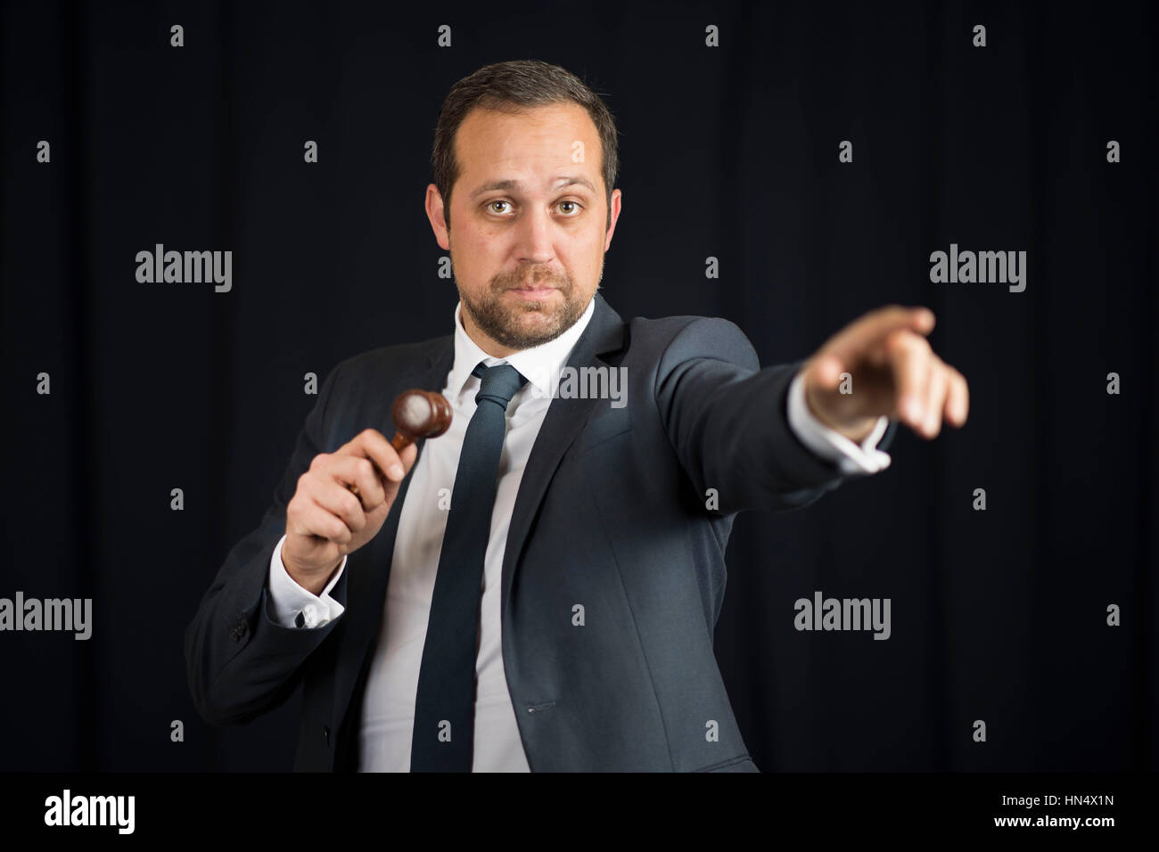 Un banditore maschio in azione di foratura di un martello durante un live auction. Foto Stock