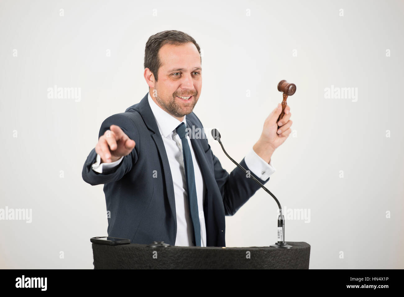 Un banditore maschio in azione di foratura di un martello durante un live auction. Foto Stock