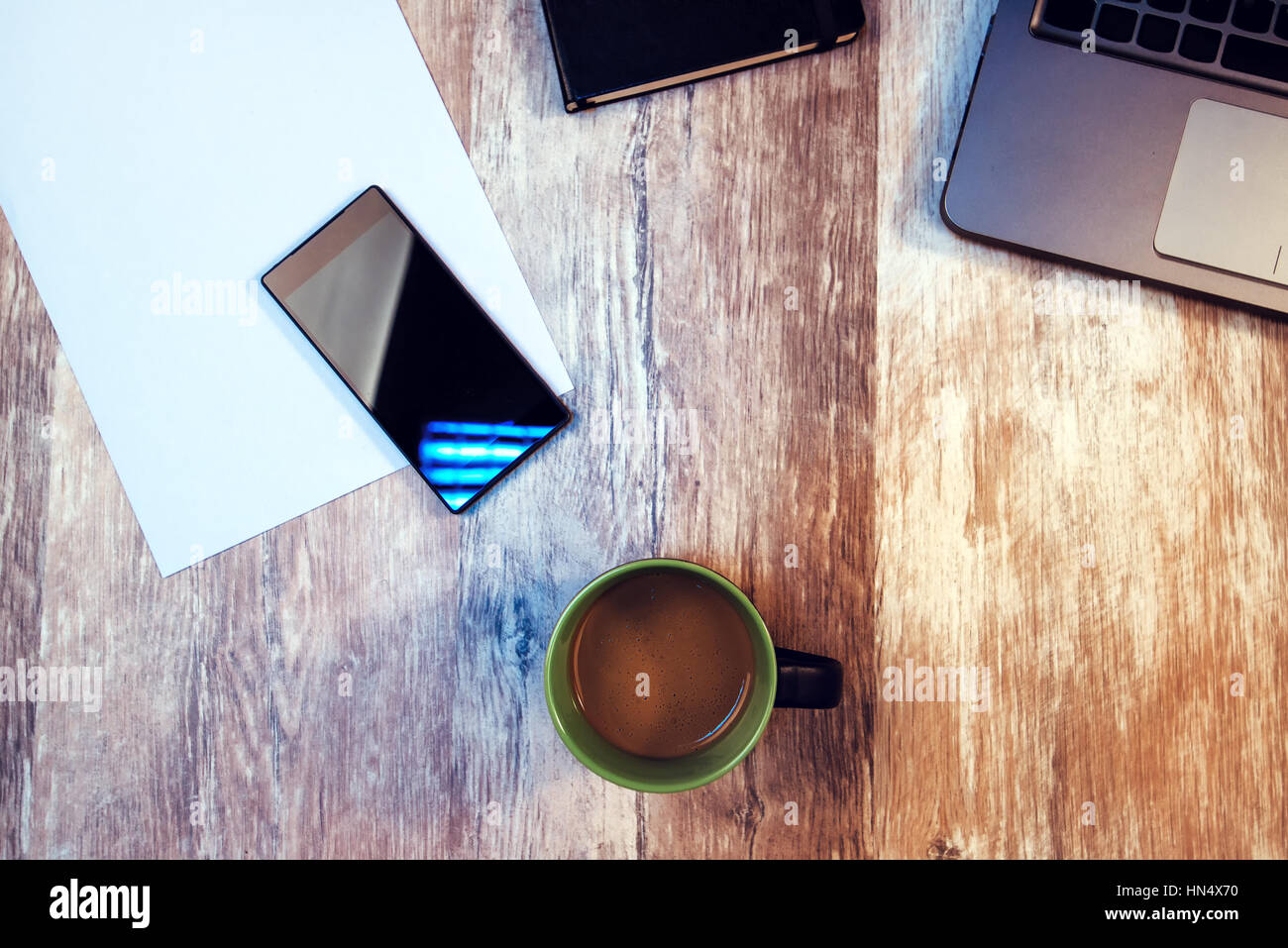 Coffee break, tempo di prendere in pausa dal vostro lavoro - cup con caffè caldo drink sulla scrivania in ufficio tra lo smartphone e il computer portatile Foto Stock