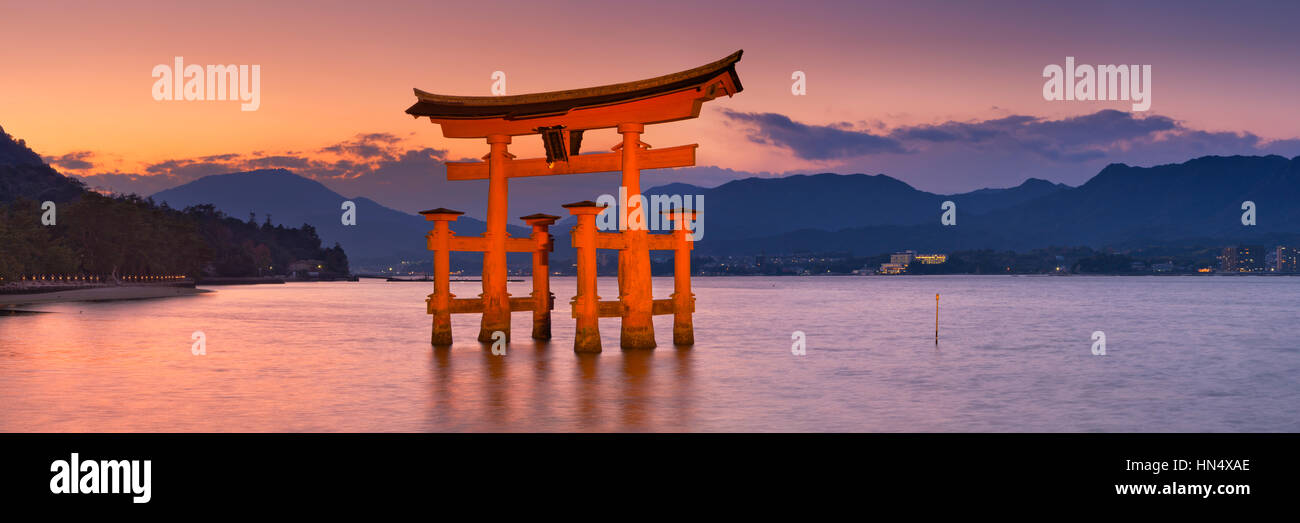 Il famoso torii gate del santuario di Itsukushima (厳島神社) su Miyajima (厳島). Fotografato al tramonto. Foto Stock