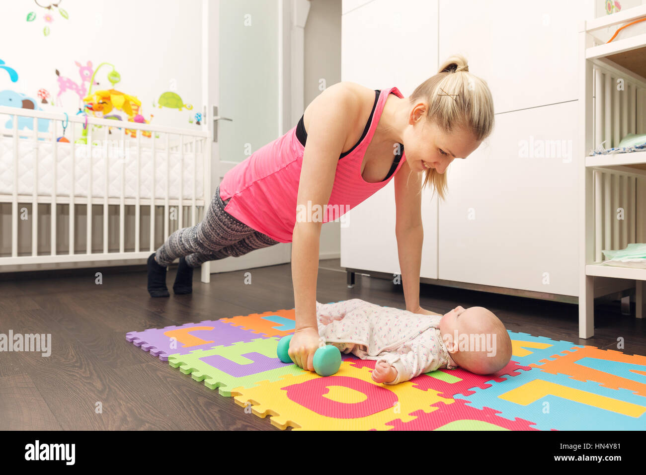 Madre di fare fitness e giocare con il suo bambino Foto Stock