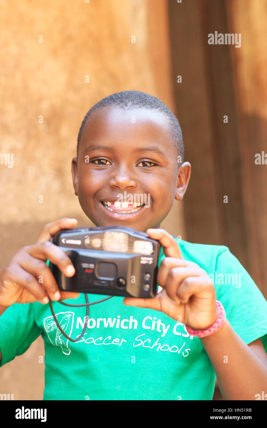 Ritratto di attraente sano giovane ragazza ugandese di sorridere alla telecamera tenendo una fotocamera da 35mm a scuola Foto Stock