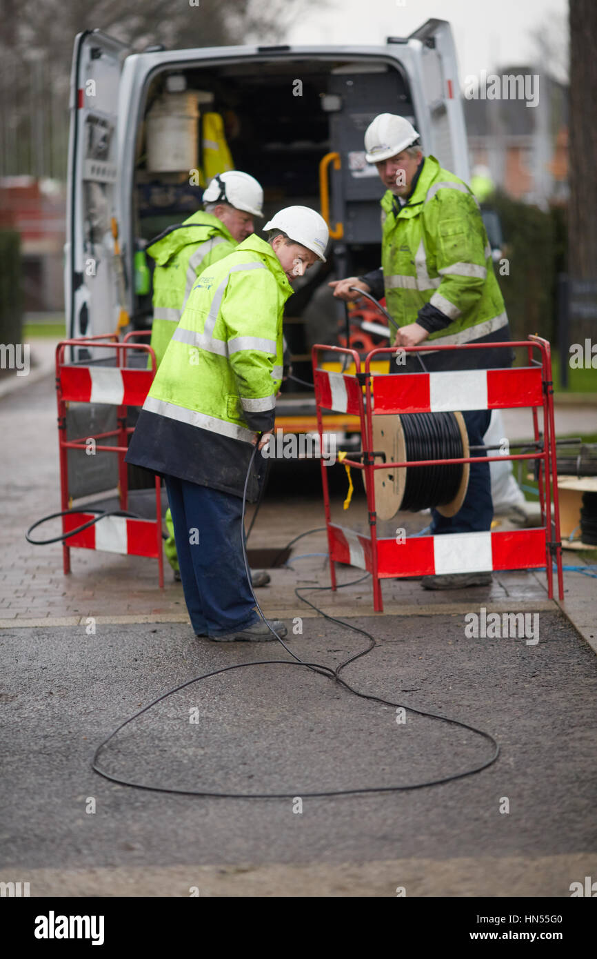 BT British Telecommunications Openreach ingegneri team di collaboratori laici in fibra ottica via cavo a banda larga alla porta Internet per una nuova strada di Didsbury, S Foto Stock