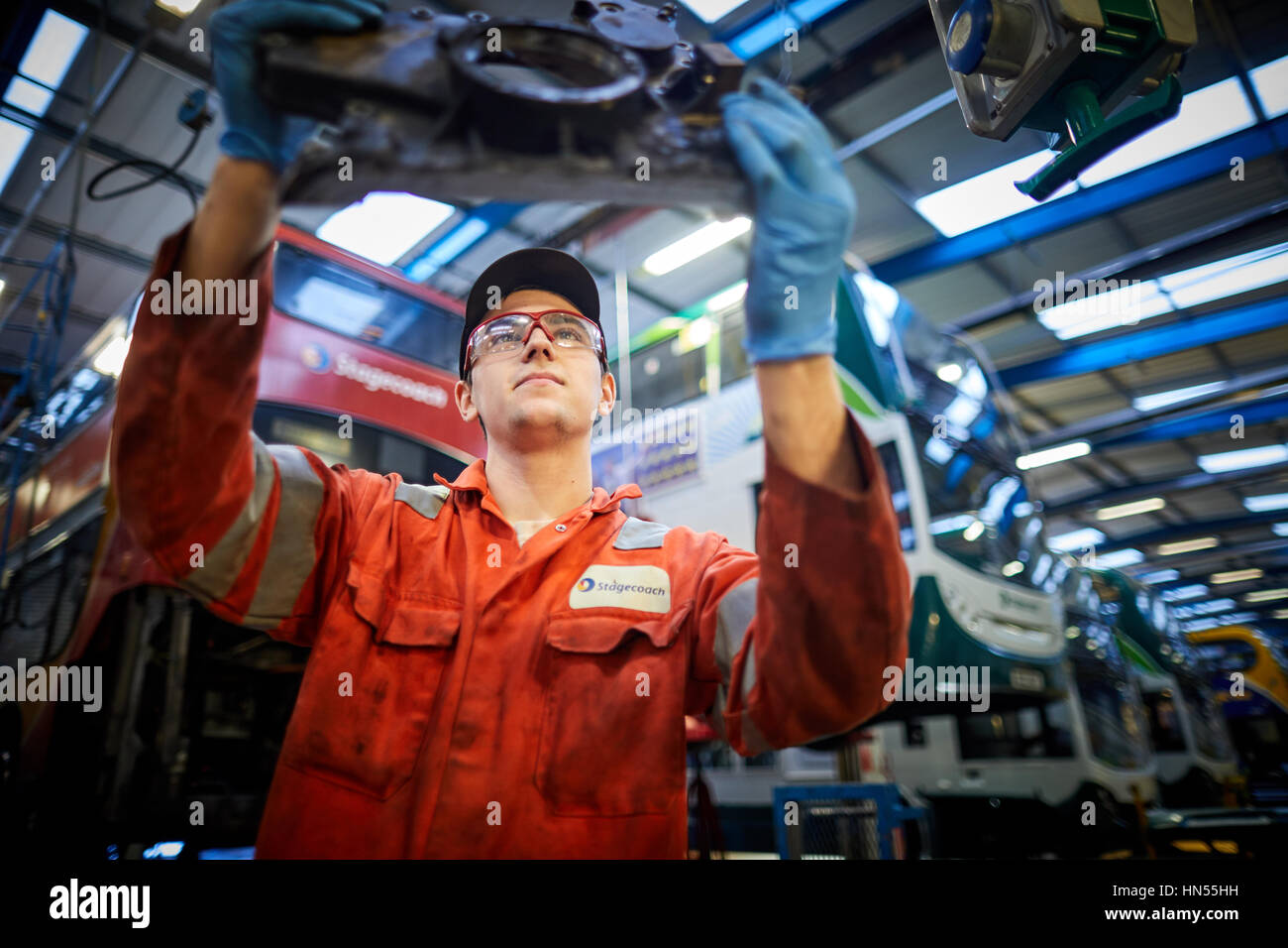 Un giovane apprendista adolescente montatore meccanico che fissa ripartiti double decker bus motore a Stagecoach operatori di autobus Wythenshawe depot in Manchester, en Foto Stock