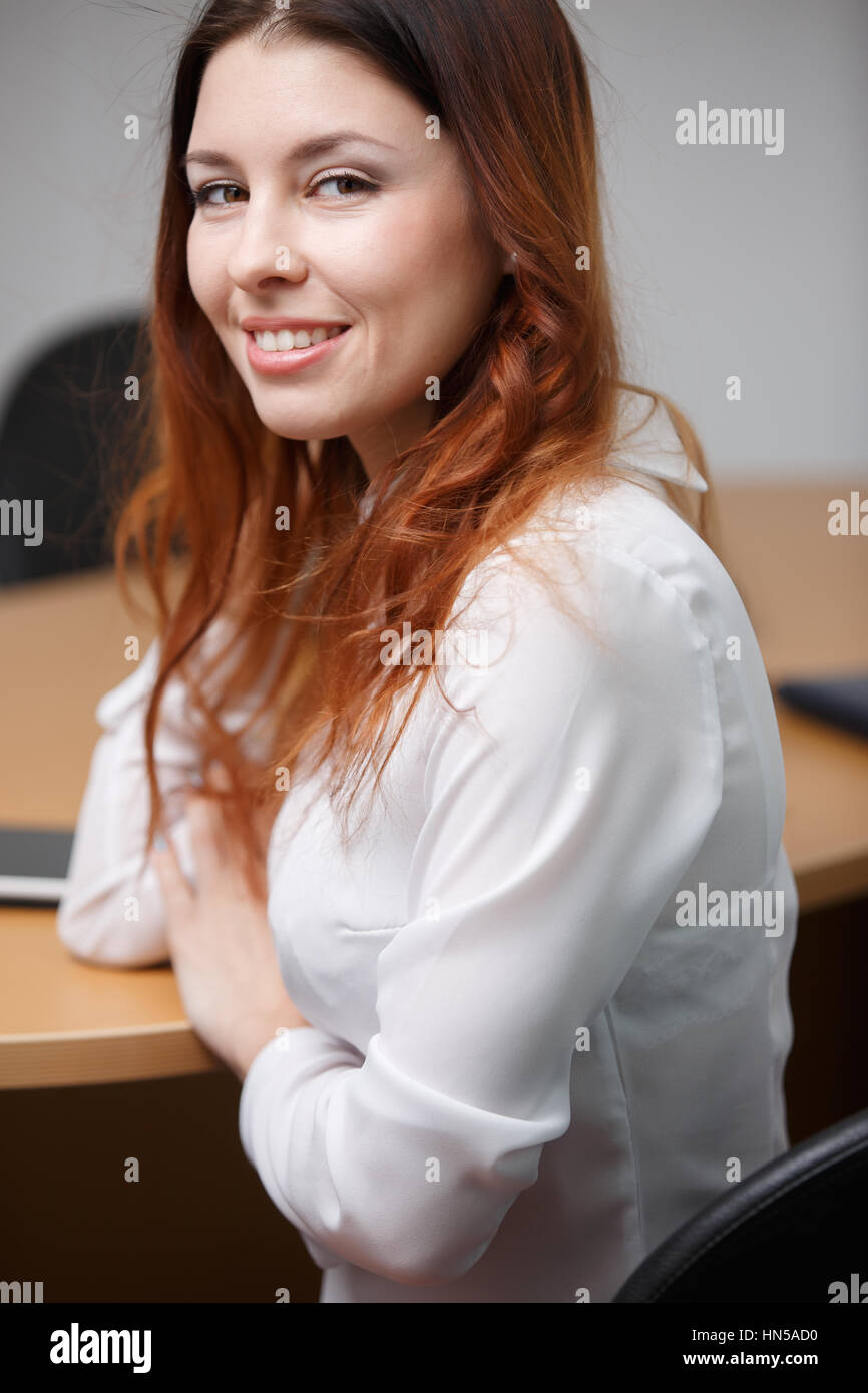 Donna sorridente in maglia bianca Foto Stock