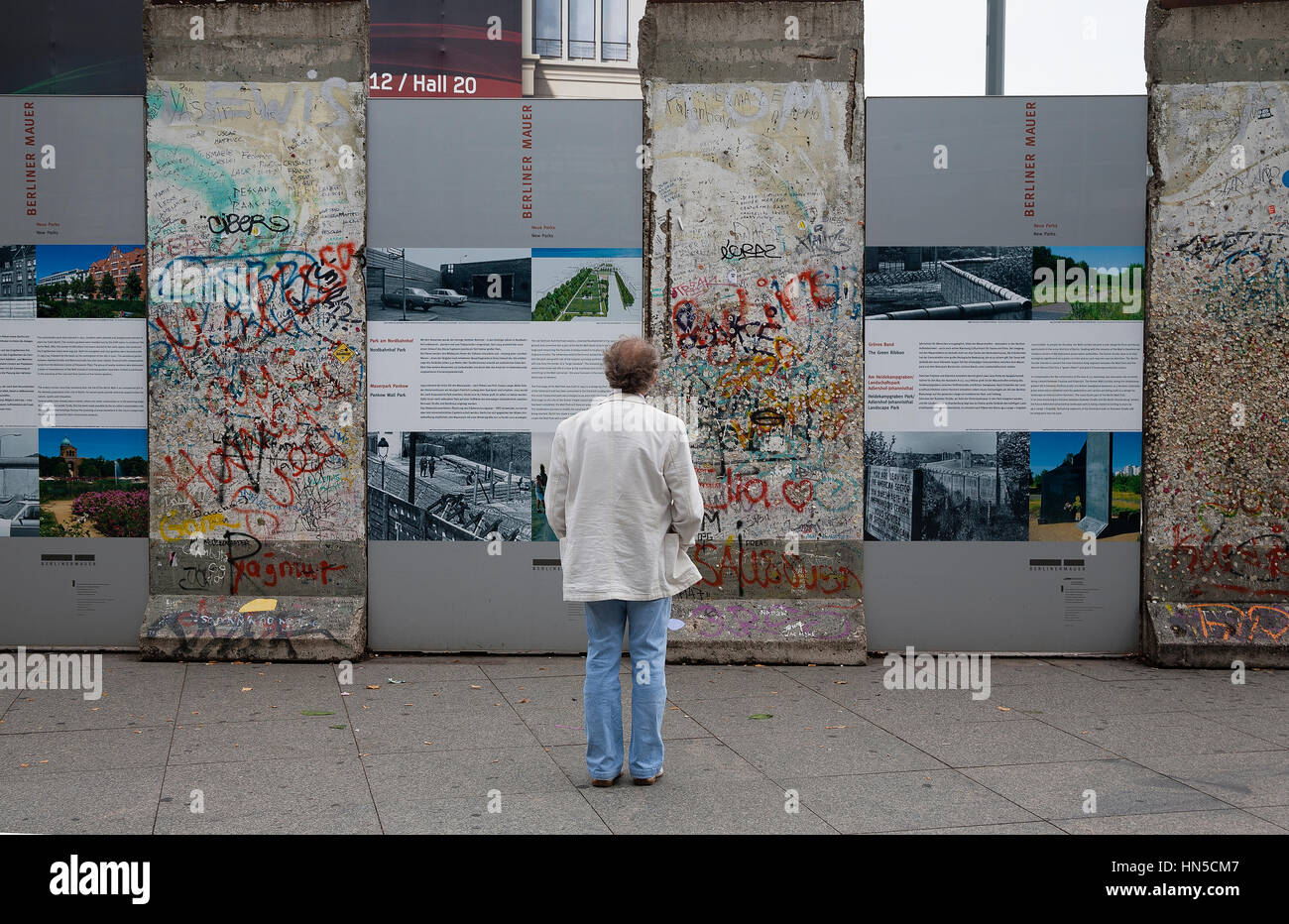 Berlino Germania. Persona che guarda la sezione del muro di Berlino è stata eretta come un display. Foto Stock